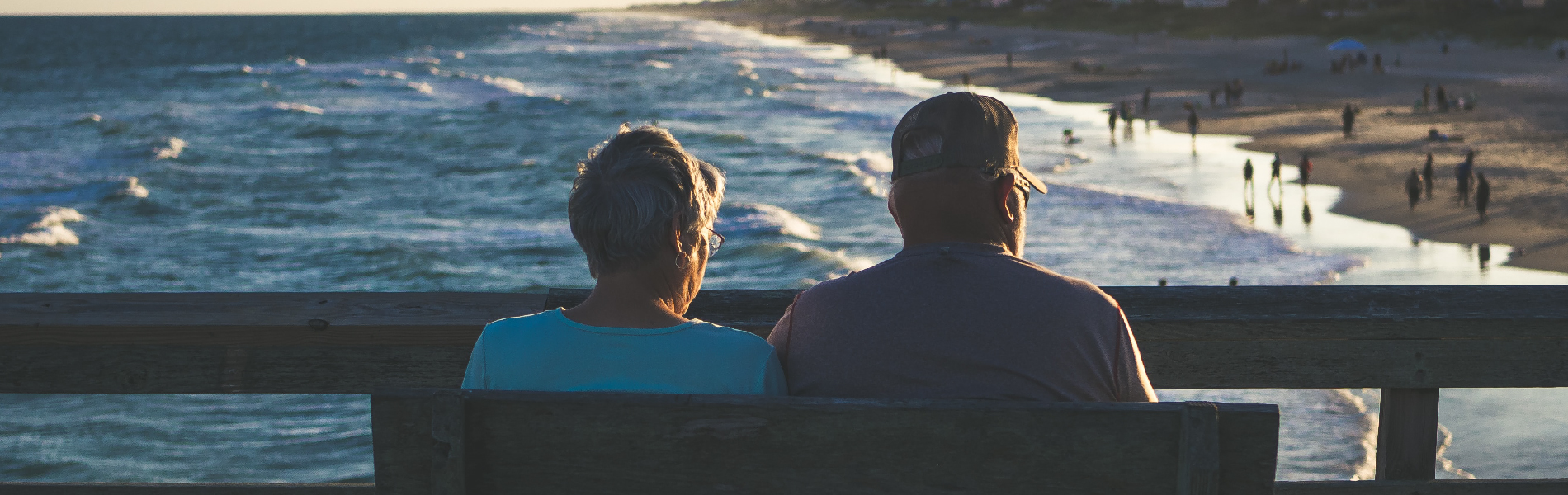 Elderly couple watching waves at the beach